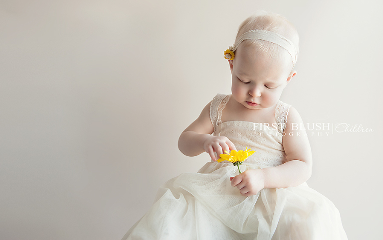 Toddler picking petals off a flower
