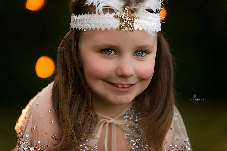 Little girl smiles at the camera using First Blush philosophy near Red Deer Alberta
