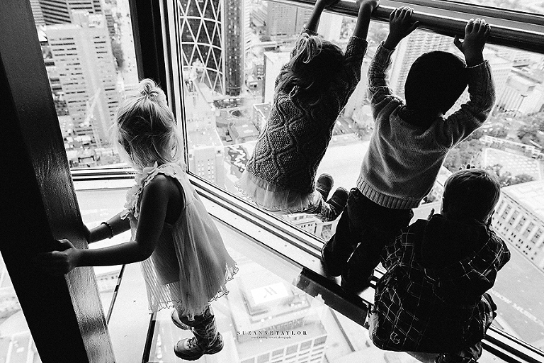 Three kids enjoy the view while one is scared at the Calgary Tower