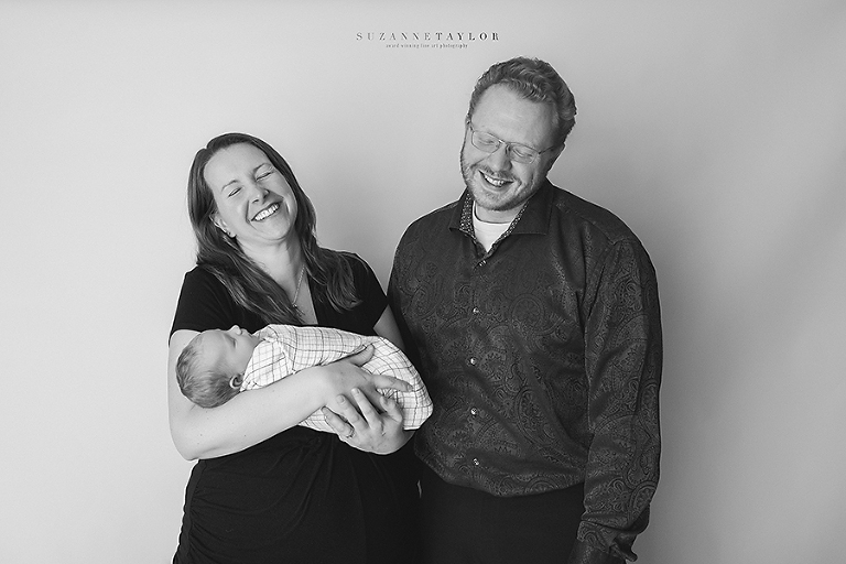Mom and Dad share a laugh together while holding their new baby