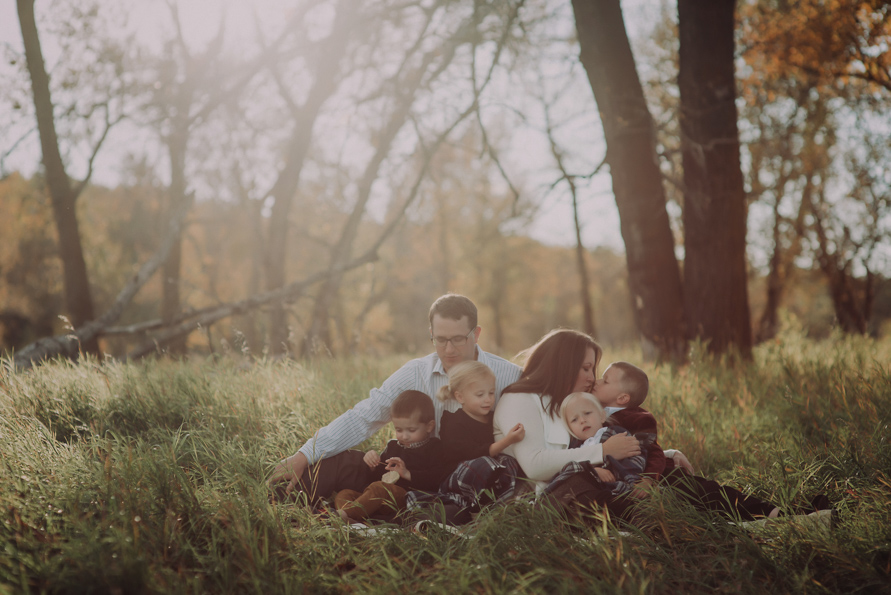 Red Deer Photographer, Suzanne Taylor sitting in the long grasses of Fish Creek Park in Calgary, Alberta with her family.