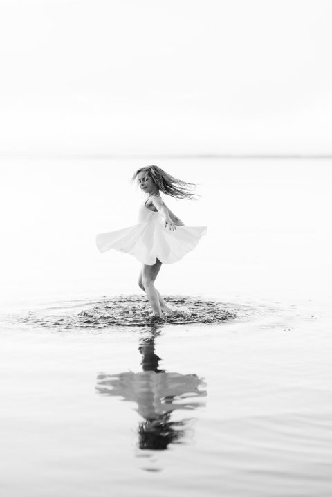 black and white image of a young female dancer in gull lake twirling captured by Suzanne Taylor Photography